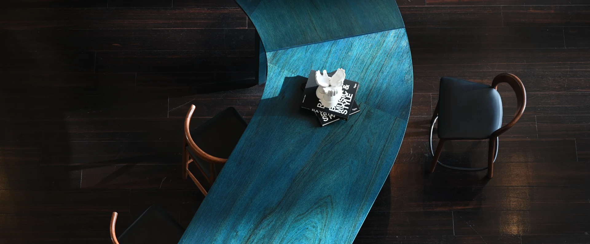 A curved blue table in a hospitality interior, photographed by IDE